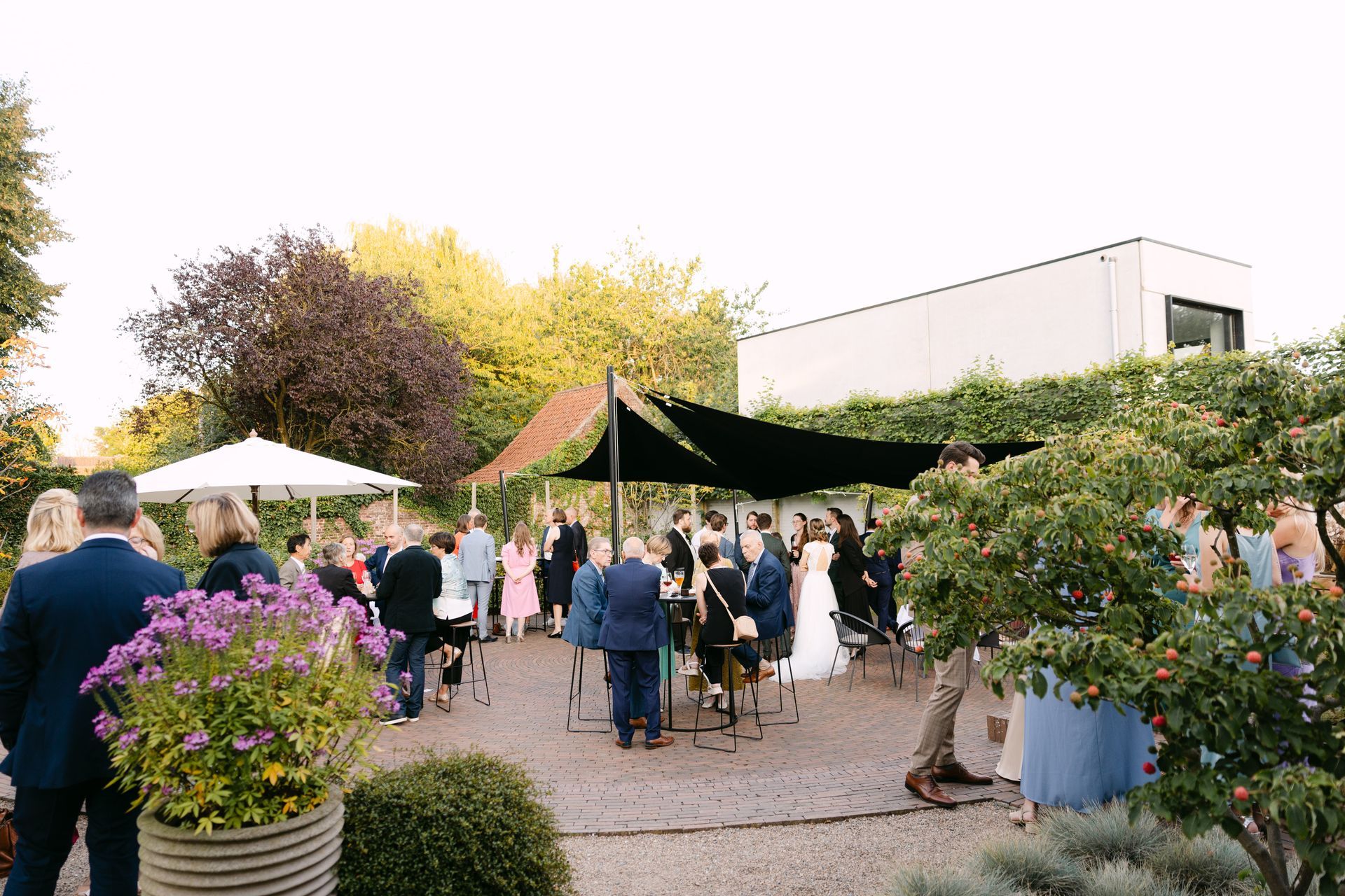 Een man staat voor een tafel met eten erop. Dit is het tuinterras van feestzaal t'Hoornaerts, Kachtem, Izegem, Roeselare.