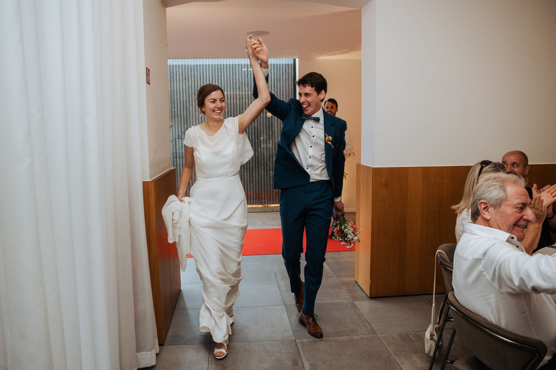 Een bruid en bruidegom lopen hand in hand door de feestzaal van t'Hoornaerts.