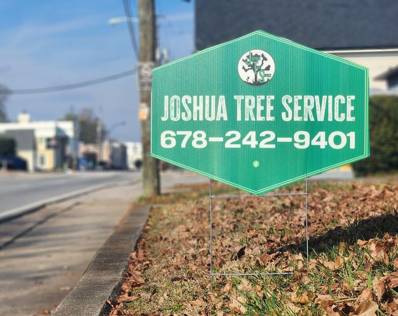 A green sign that says joshua tree service on it