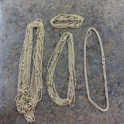 A bunch of gold chains are laying on a table