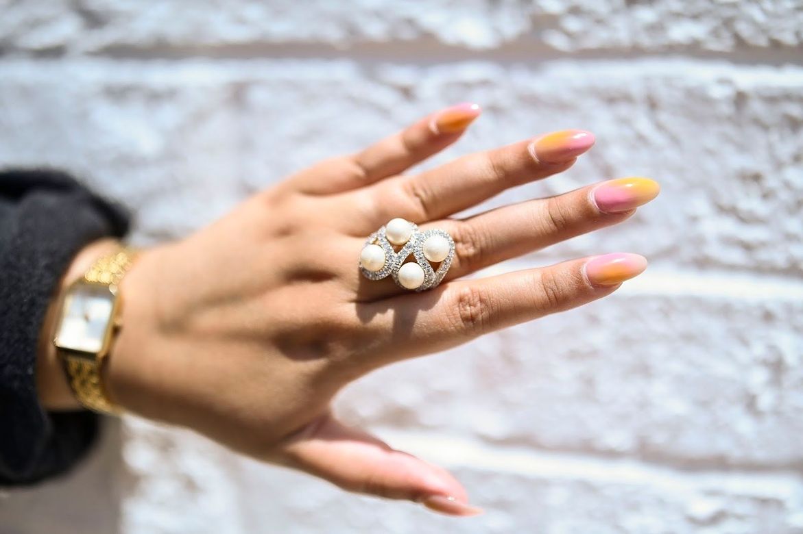 A woman 's hand with a ring on it and a watch on her wrist.