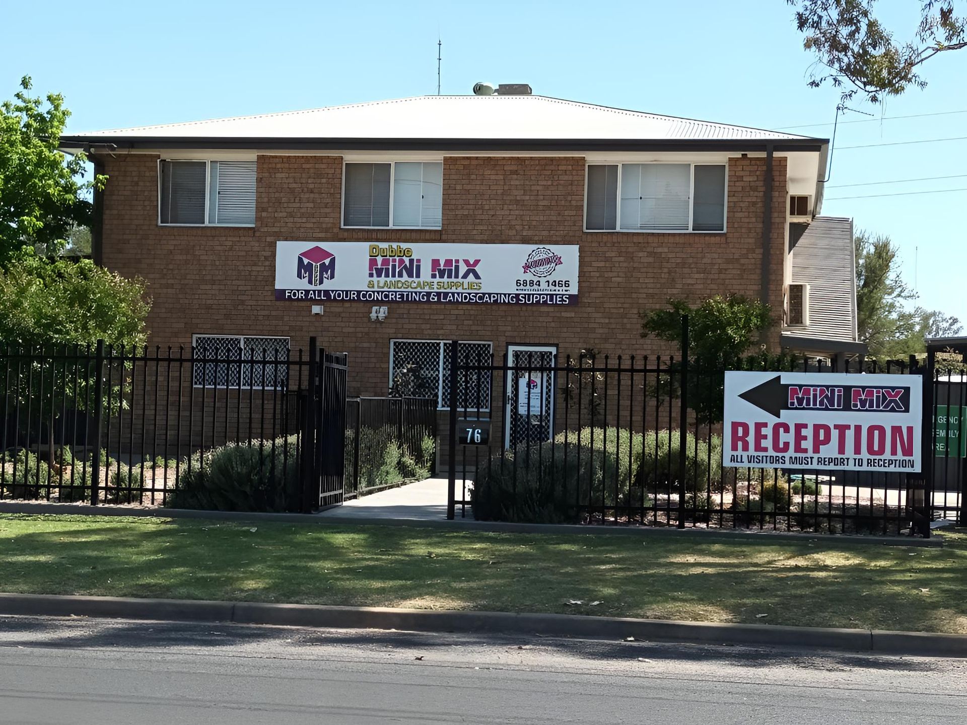 A Concrete Walkway Leading To A Building With Palm Trees In The Background — Dubbo Mini Mix & Landscape Supplies In Dubbo, NSW