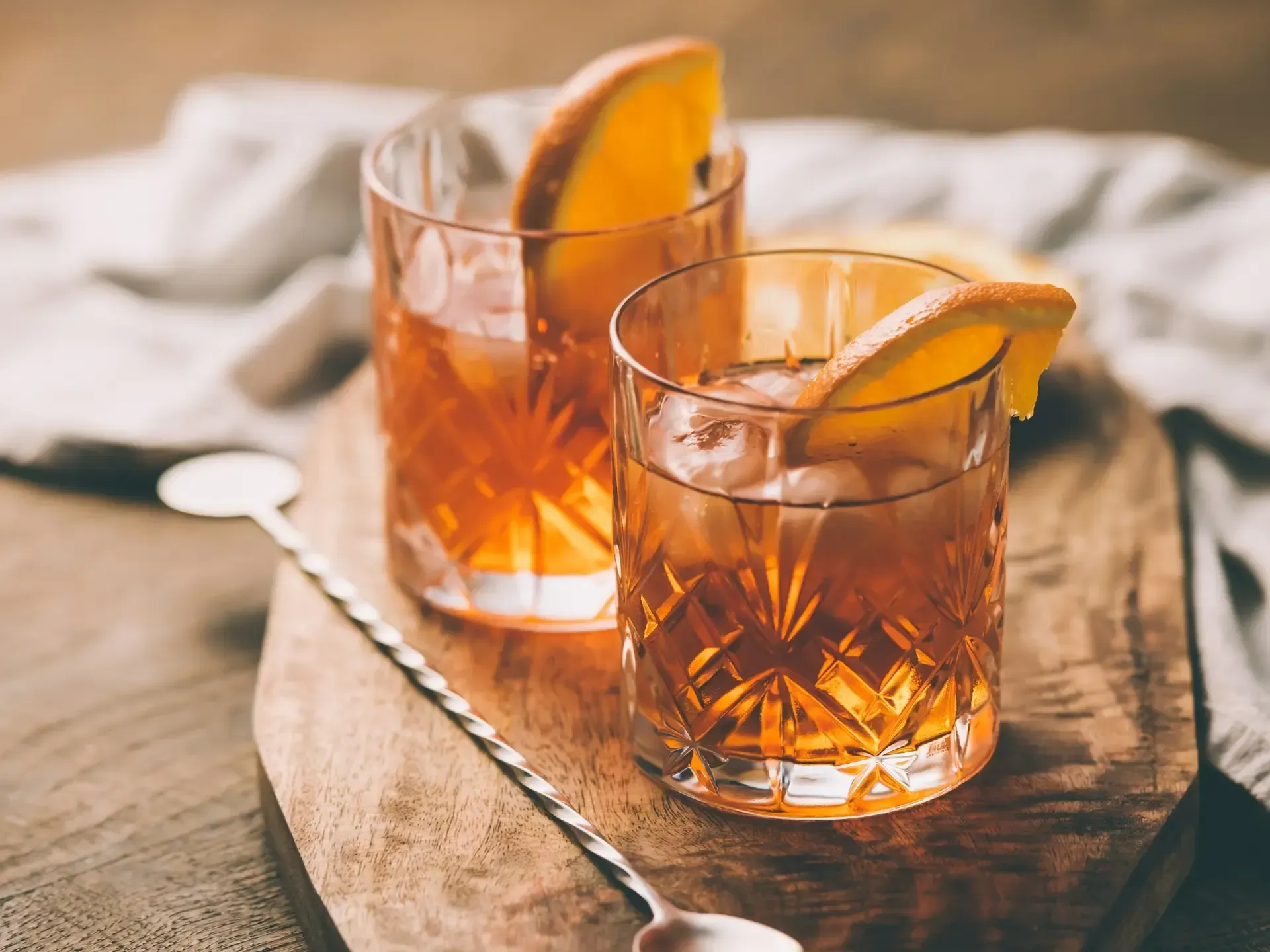 Two old fashioned drinks with orange slices