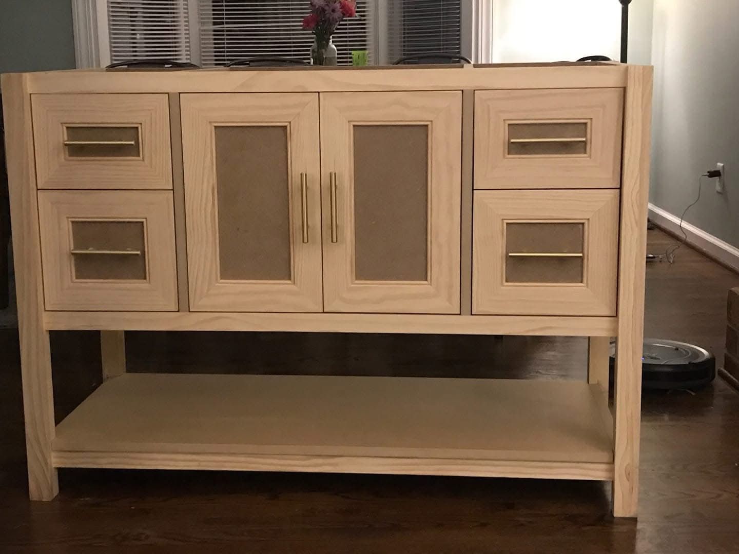 Light wood bathroom vanity with gold hardware.