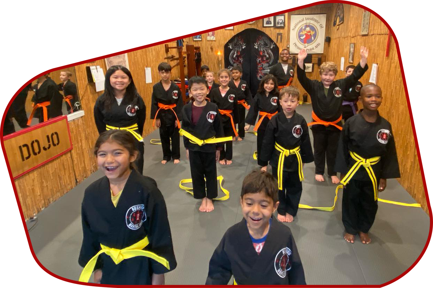 A group of children are standing in front of a sign that says dojo