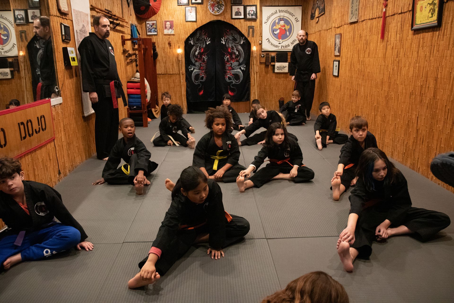 A group of children are practicing martial arts in a dojo