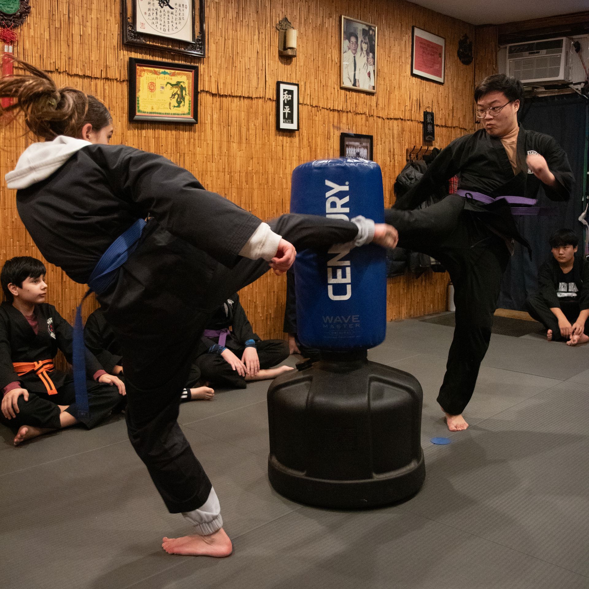 A person kicking a century bag in a gym
