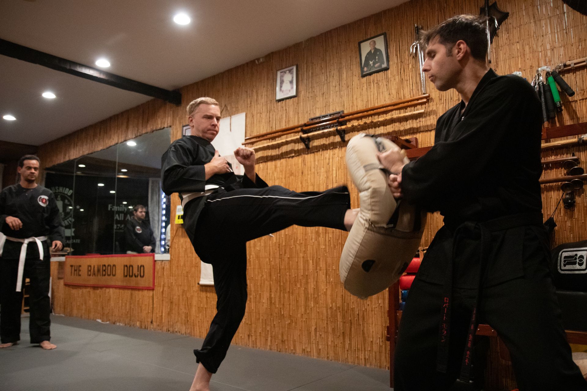Two men are practicing martial arts in a gym.