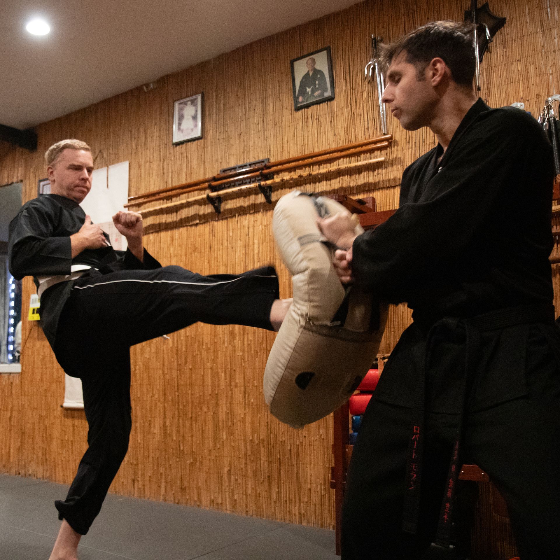 two young men are practicing karate in a gym