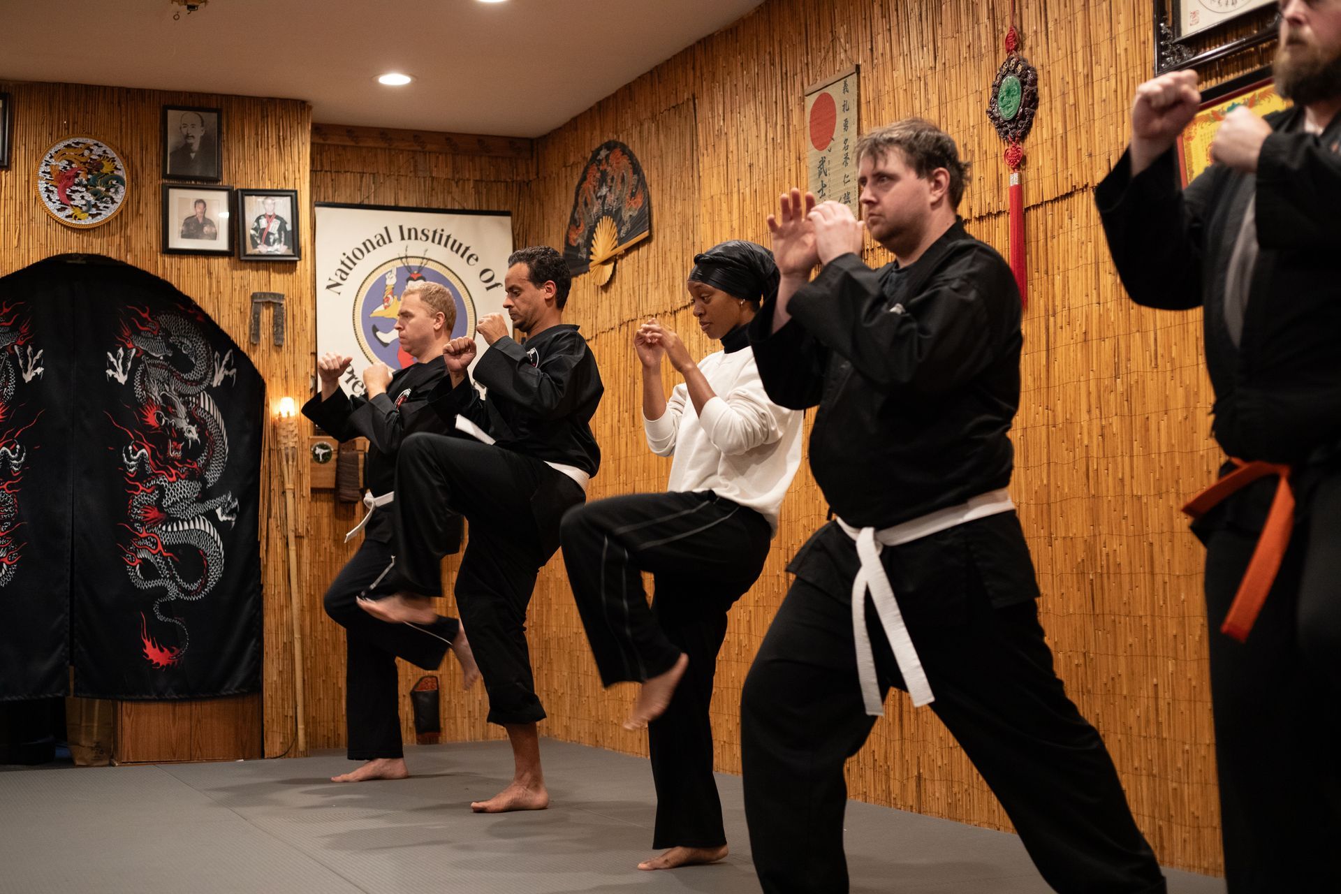 A group of people are practicing martial arts in a gym.