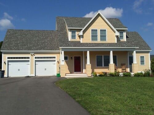A large house with two garage doors and a porch