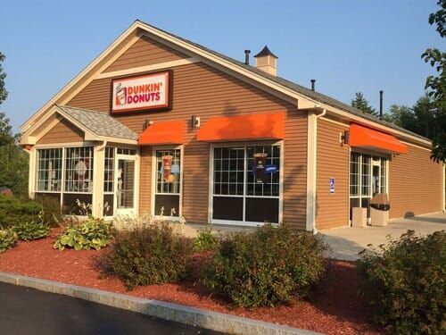 A dunkin donuts restaurant with an orange awning