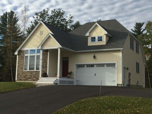 A yellow house with a white garage door