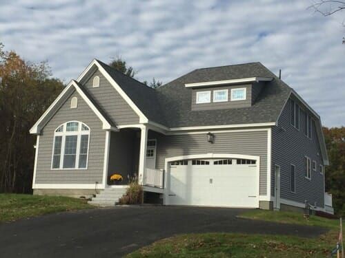 A large gray house with a white garage door