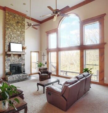 A living room with lots of windows and a fireplace