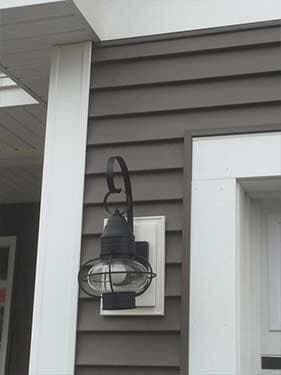 There is a light on the side of a house.