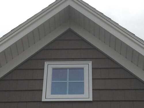 The roof of a house with a window on it.