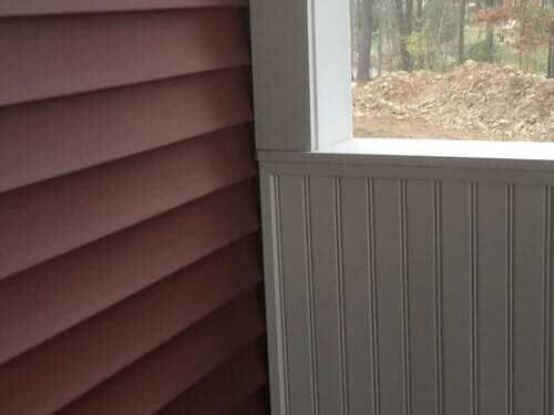There is a window in the corner of the room with a view of the woods.