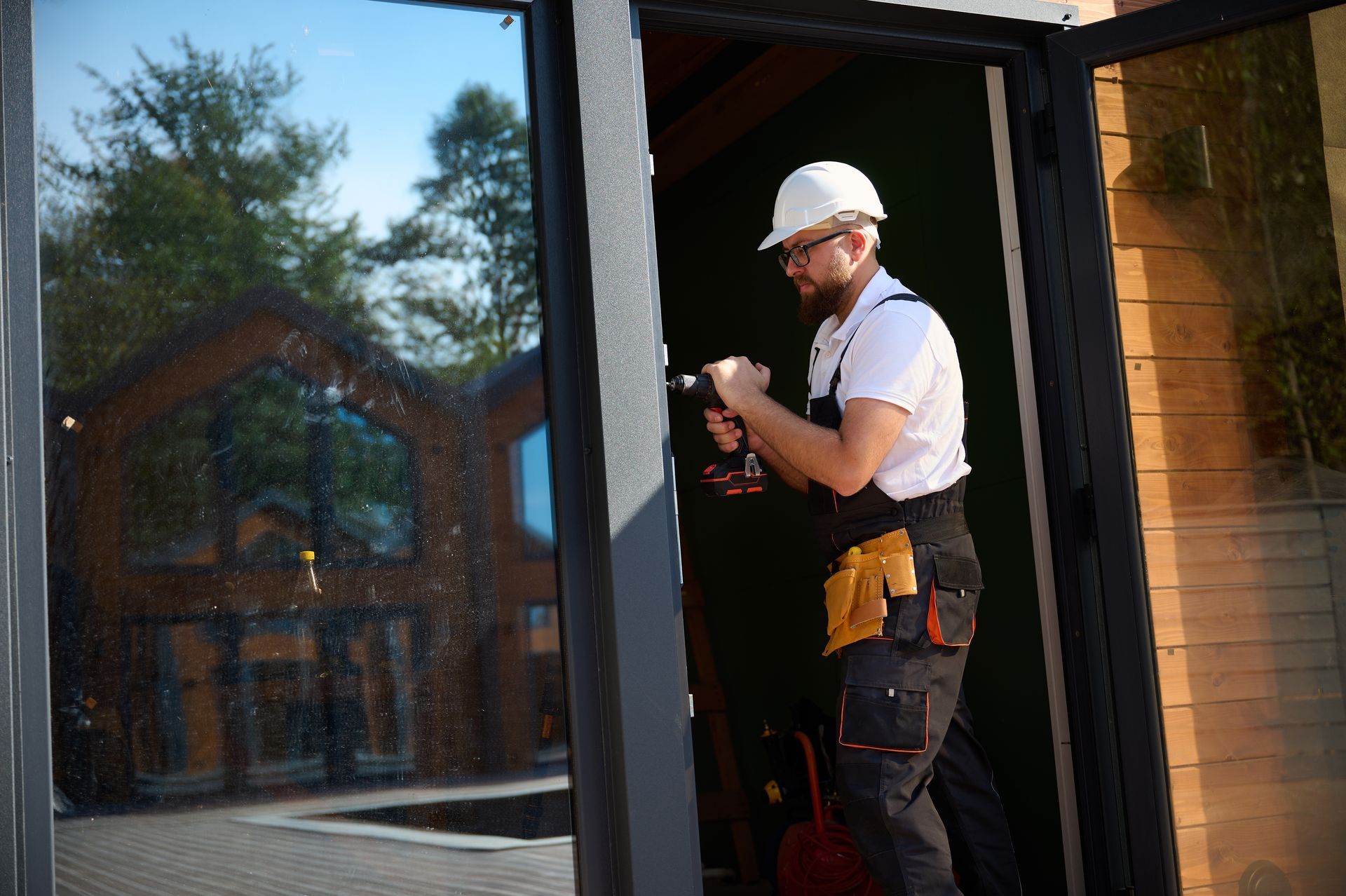 Two men are installing a window in a house.