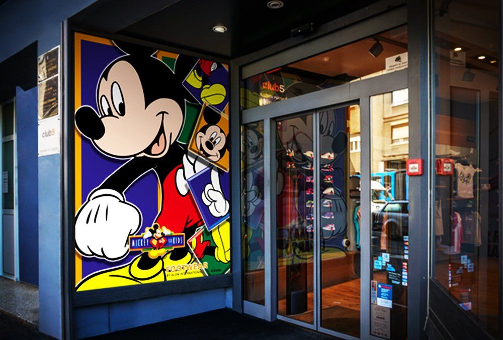 A store front with a painting of mickey mouse on it