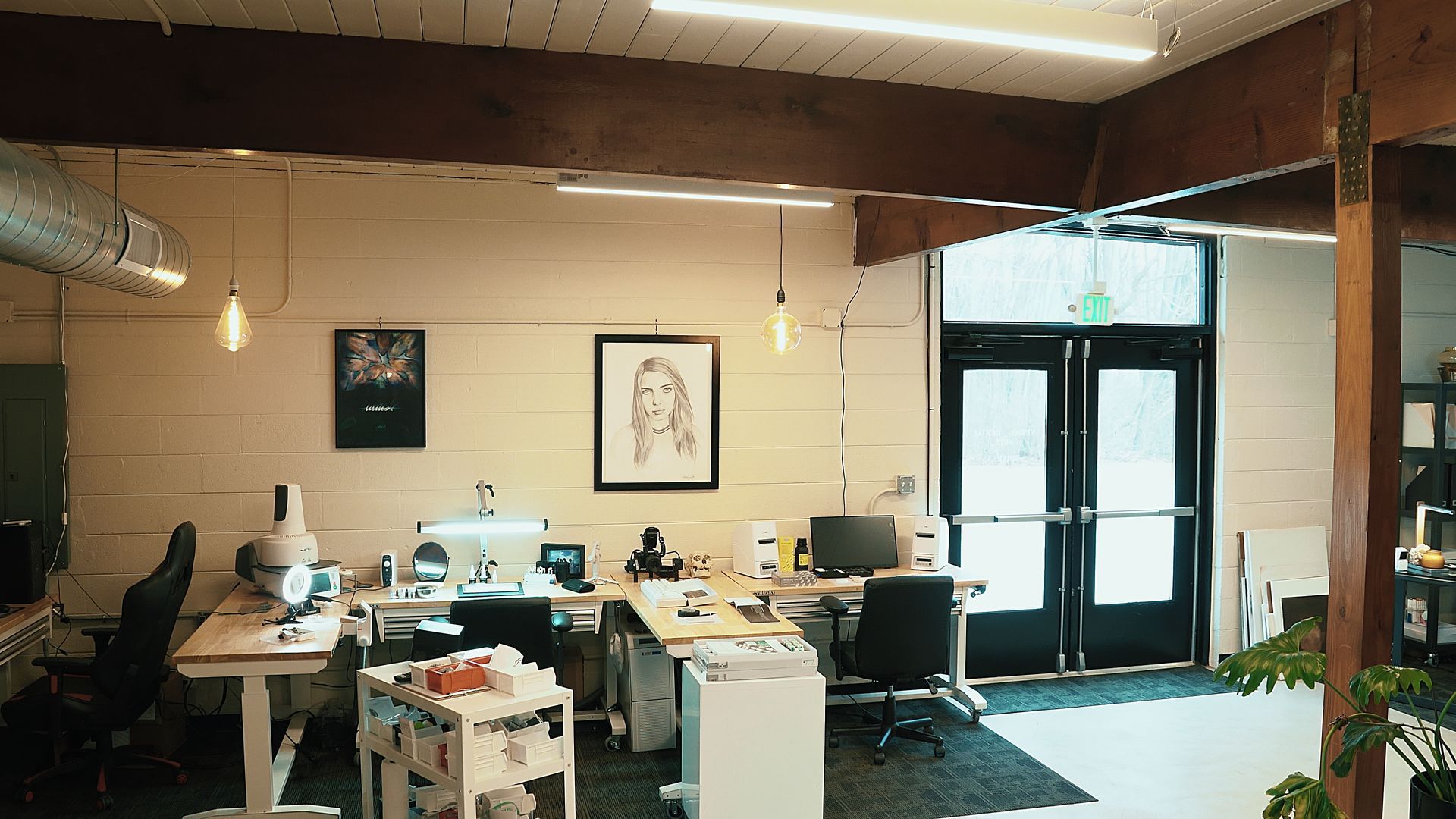 An dental office with a lot of desks and chairs and a picture on the wall.