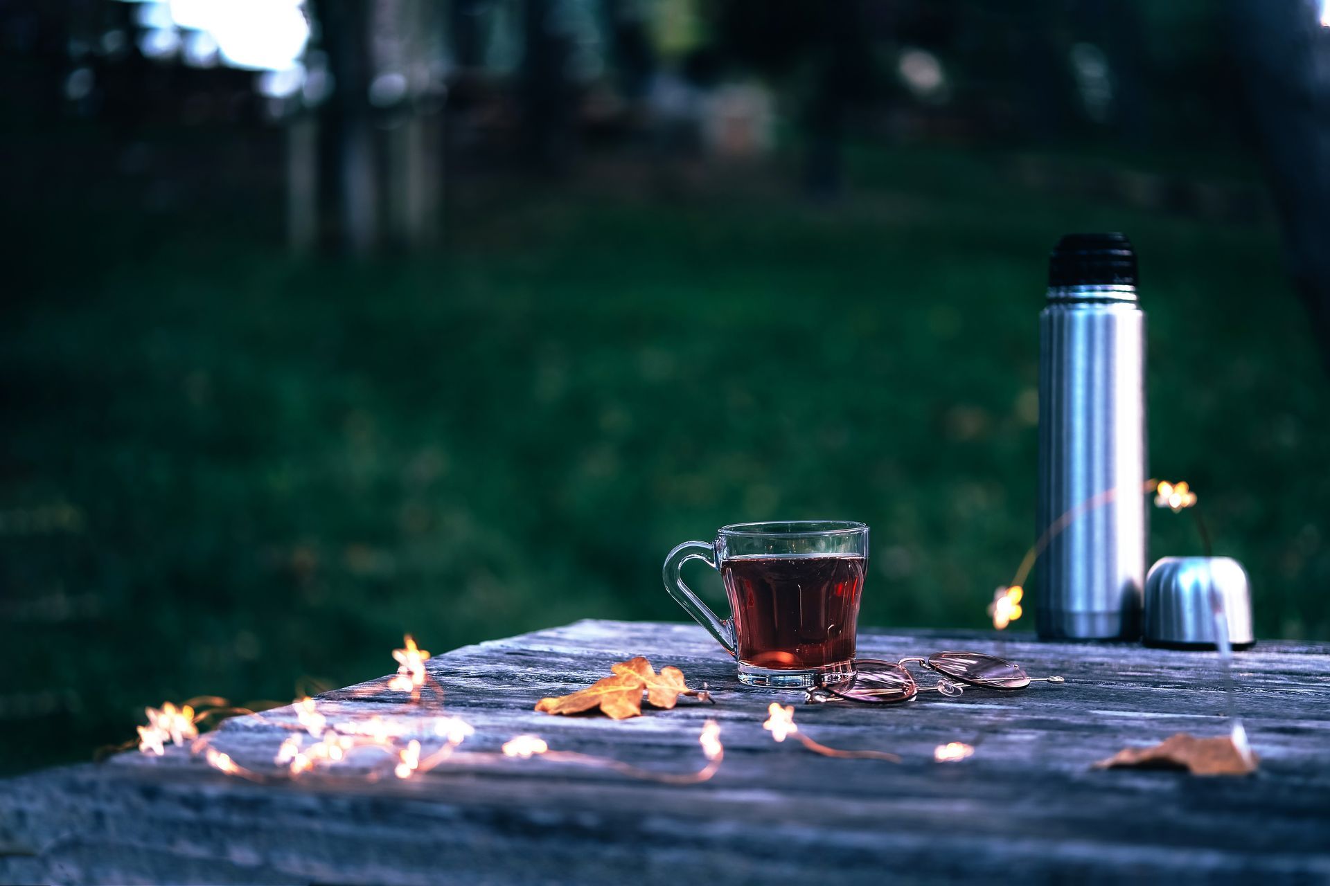 Two glasses of tea with straws on a wooden table.