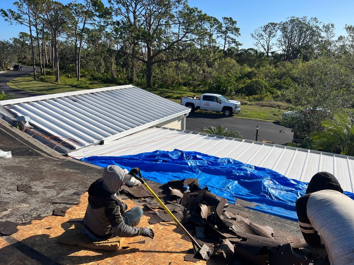 A group of people are working on the roof of a house.