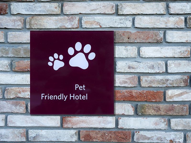 A sign on a brick wall that says pet friendly hotel