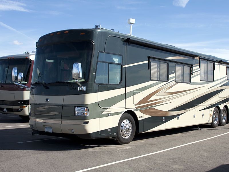 Two rvs are parked next to each other in a parking lot