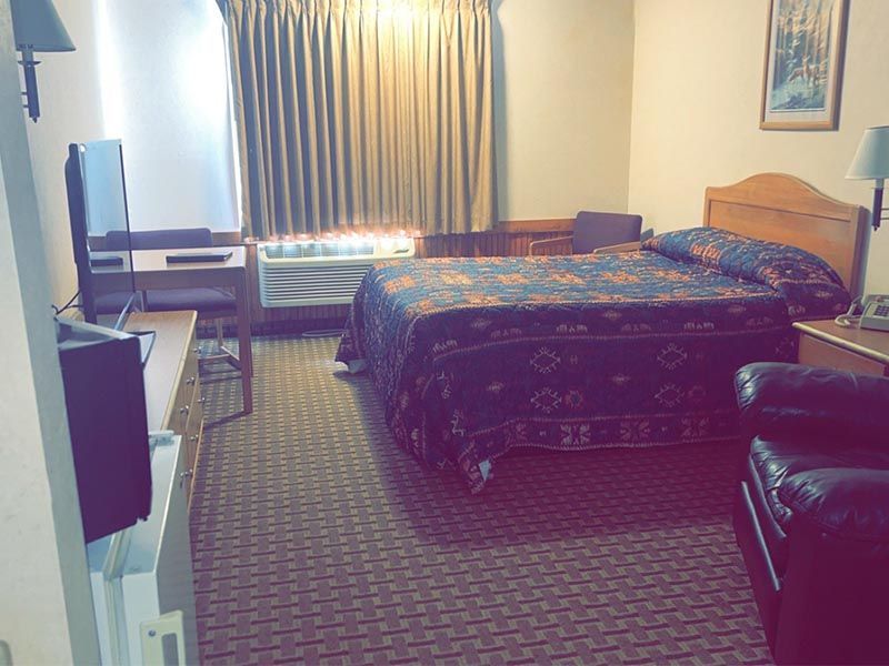 A hotel room with a king size bed and a flat screen tv