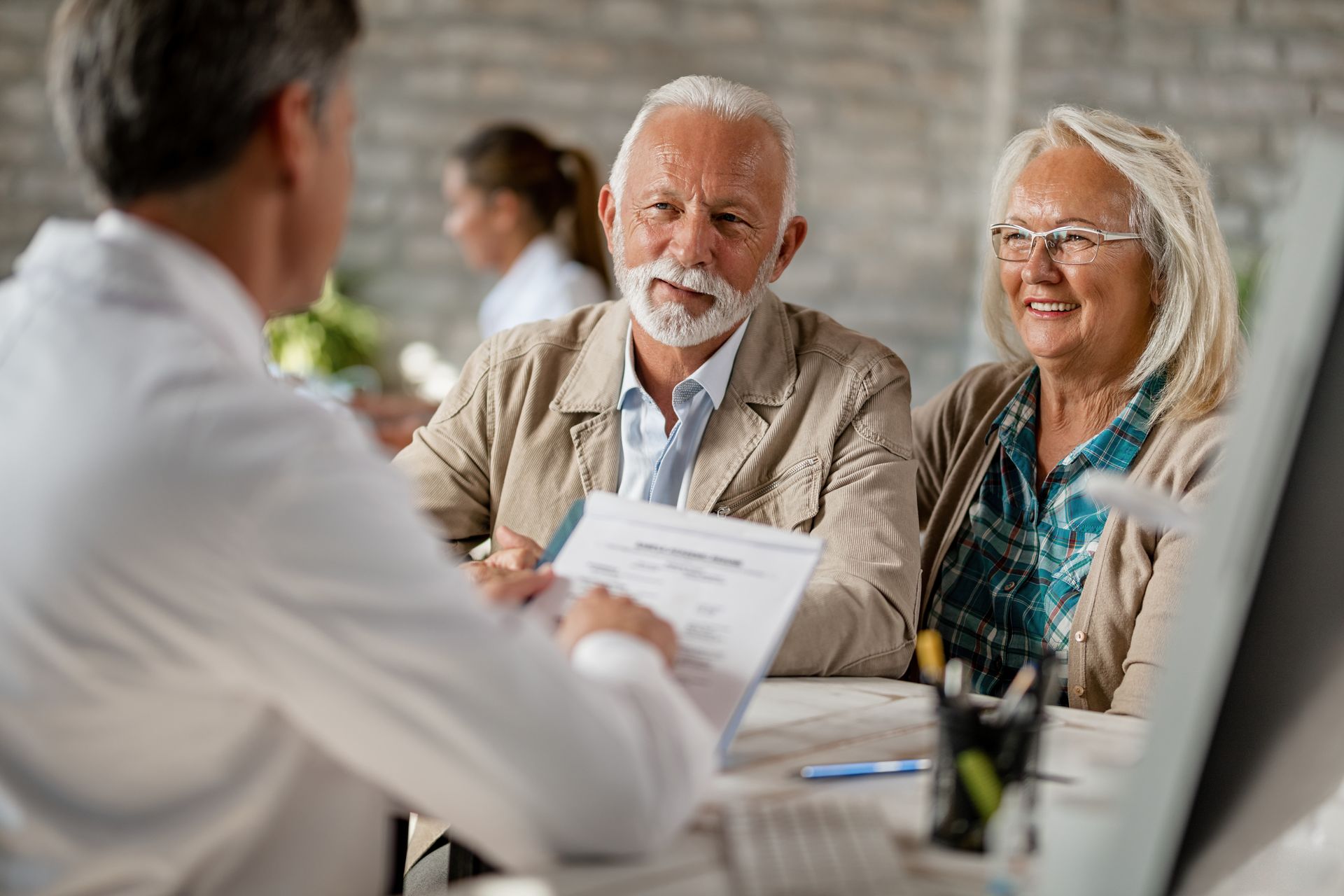 Senior couple reviewing Medicare insurance options with an advisor in Boynton Beach, FL