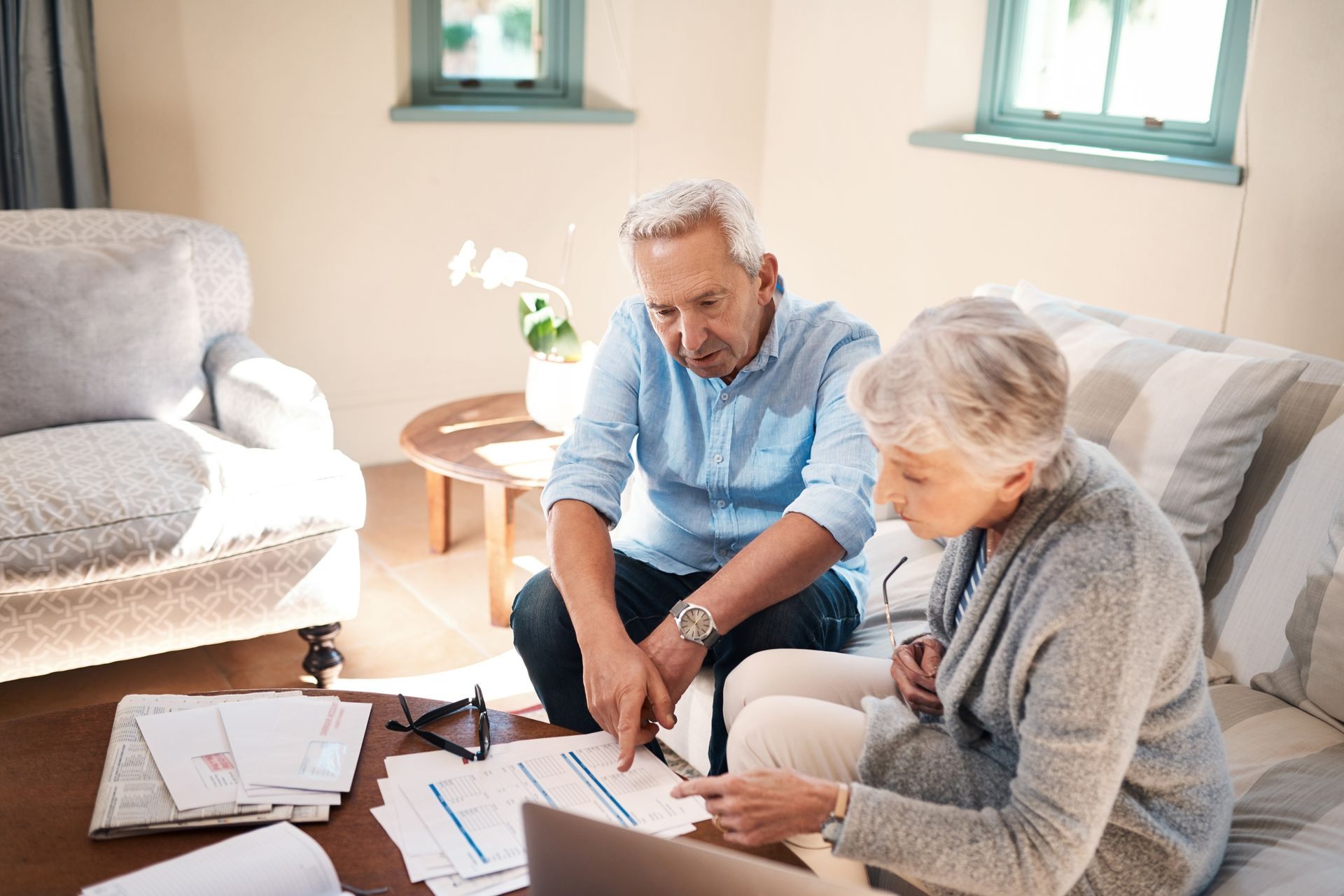 Senior couple reviewing their retirement plan together, looking concerned about the future