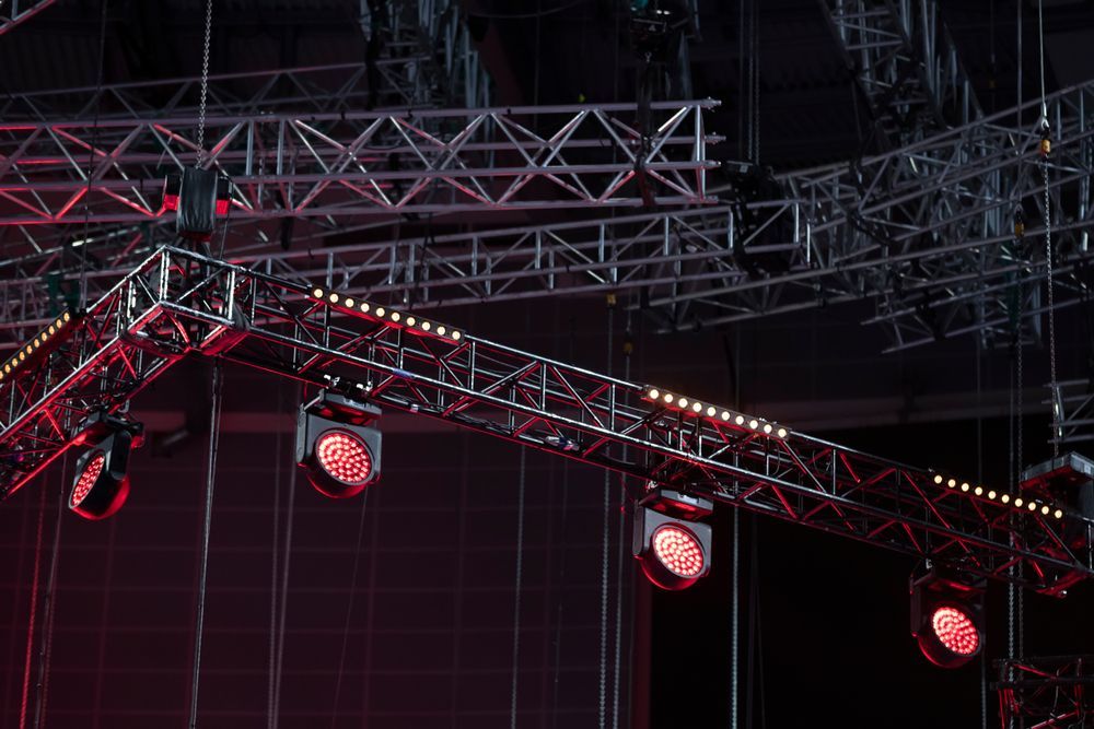 Stage Lighting Rig With Red Spotlights And Metal Trusses — Kennedy Amplifier Hire Service In South Mackay, QLD