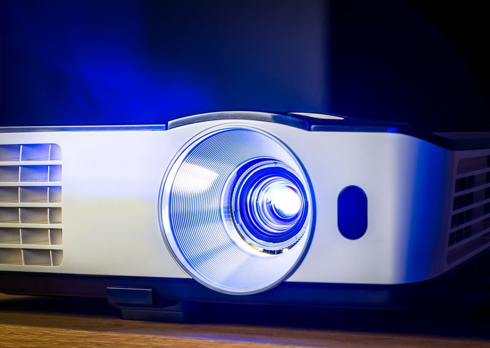 A White Projector With Blue Light Emitting From the Lens — Kennedy Amplifier Hire Service In South Mackay, QLD