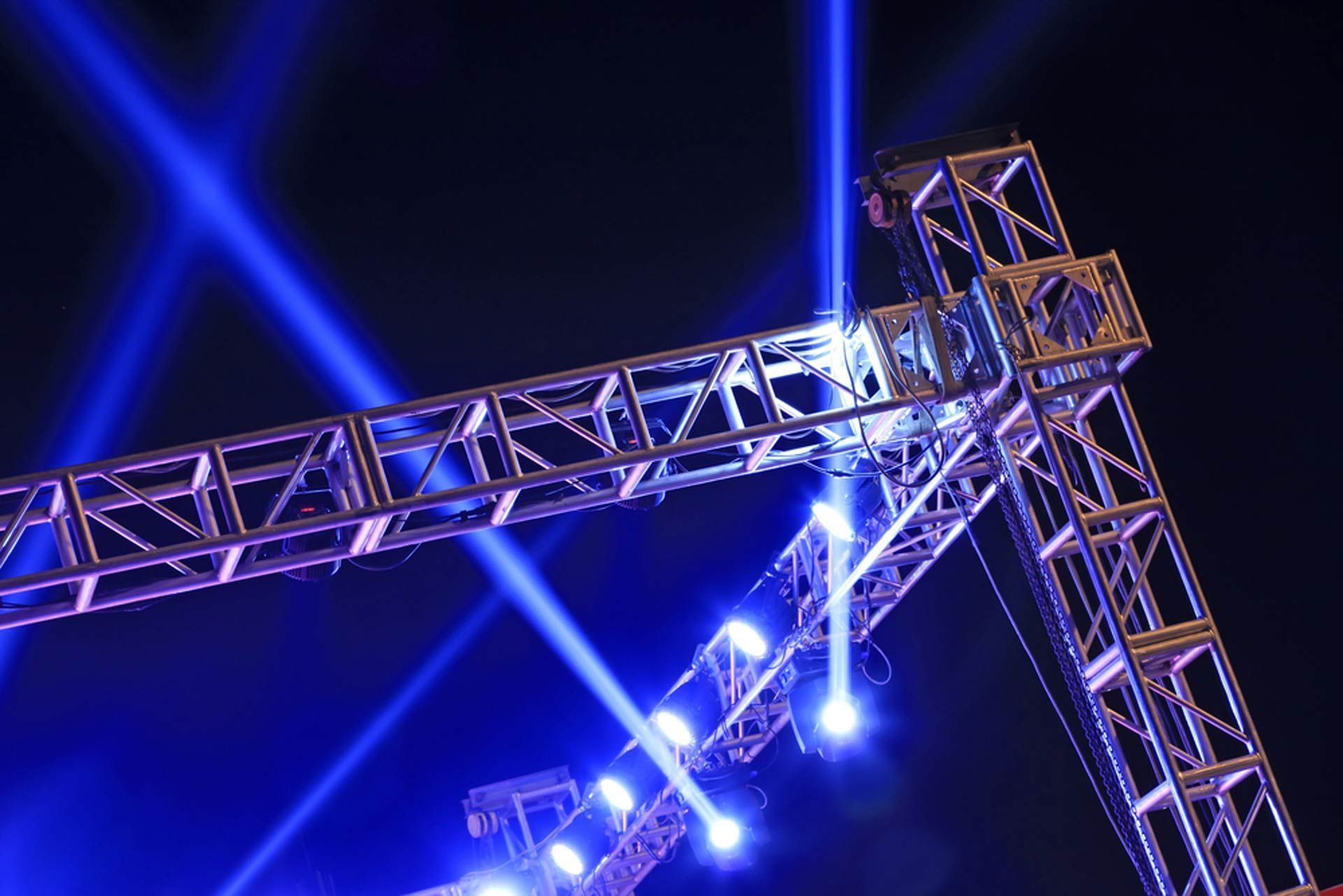 Blue Stage Lights Shining From A Metal Truss Structure — Kennedy Amplifier Hire Service In South Mackay, QLD