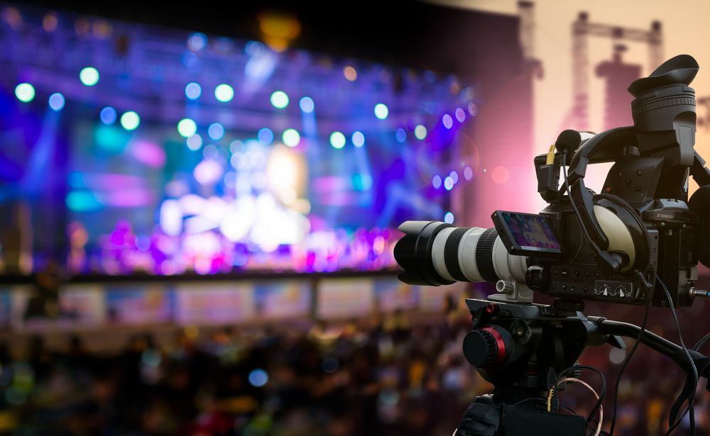 Camera Filming a Brightly Lit Stage With a Band Performing — Kennedy Amplifier Hire Service In South Mackay, QLD