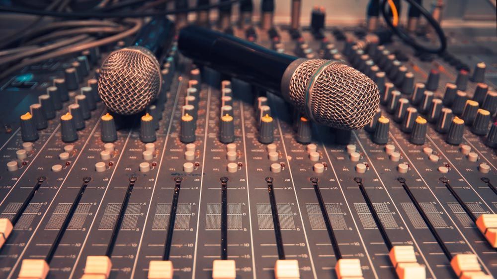 Two Microphones On A Sound Mixing Console With Sliders And Knobs — Kennedy Amplifier Hire Service In South Mackay, QLD