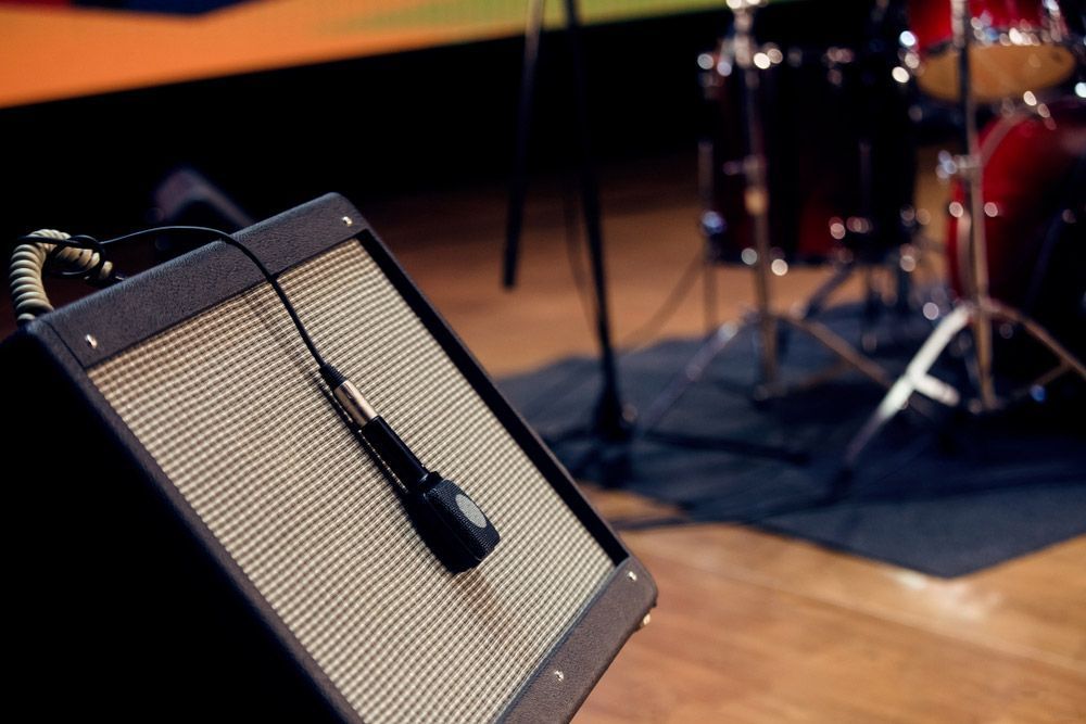 Guitar Amplifier With Microphone In Front Of A Drum Set On A Stage — Kennedy Amplifier Hire Service In South Mackay, QLD