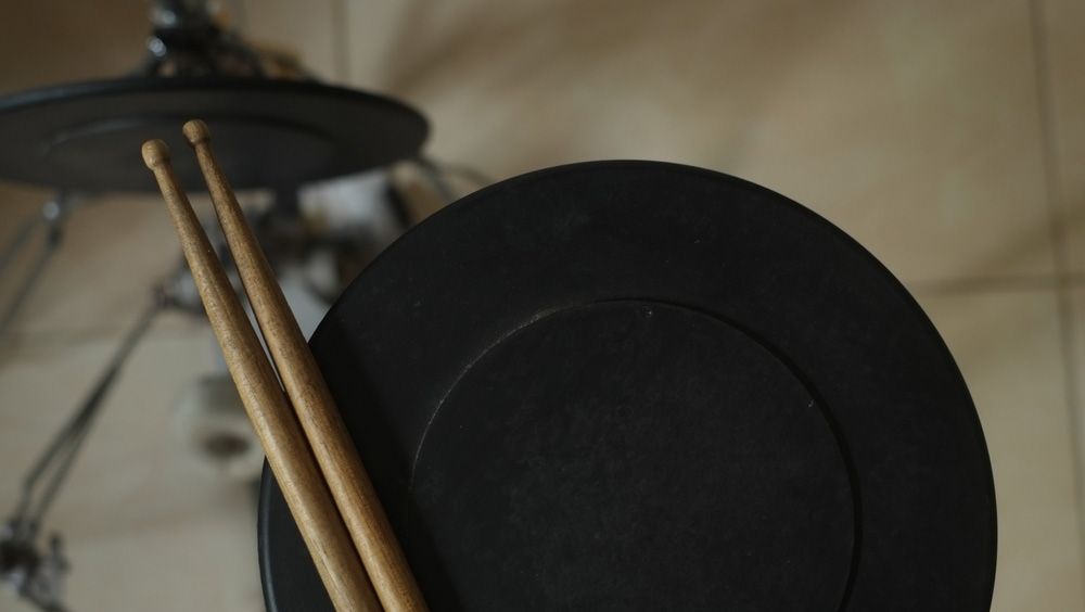 Drumsticks Resting On A Black Electronic Drum Pad — Kennedy Amplifier Hire Service In South Mackay, QLD