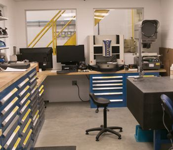 A room with a computer and a machine that says ' precision ' on it