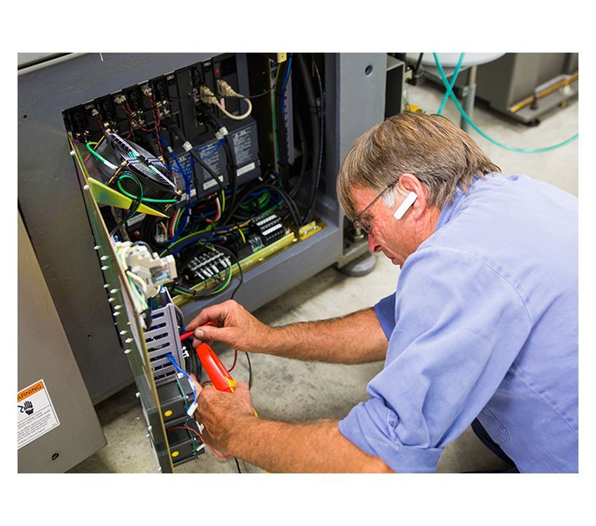 A man in a blue shirt is working on a computer.