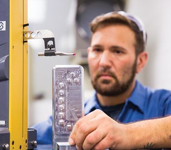 A man in a blue shirt is working on a machine