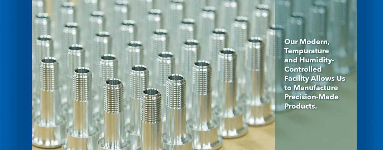 A bunch of metal screws are lined up on a table.