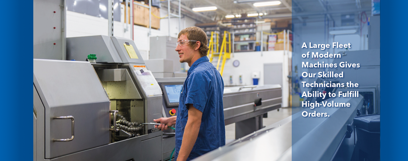 A man in a blue shirt is working on a machine in a factory.