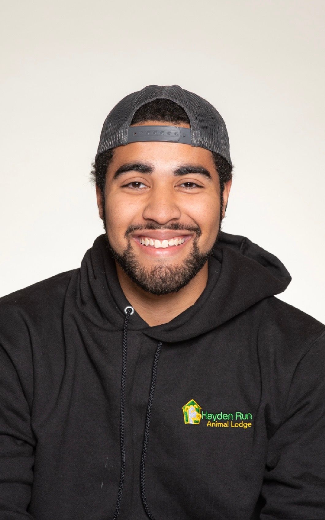 Man with short brown hair wearing a light blue polo shirt, laughing with mouth open.