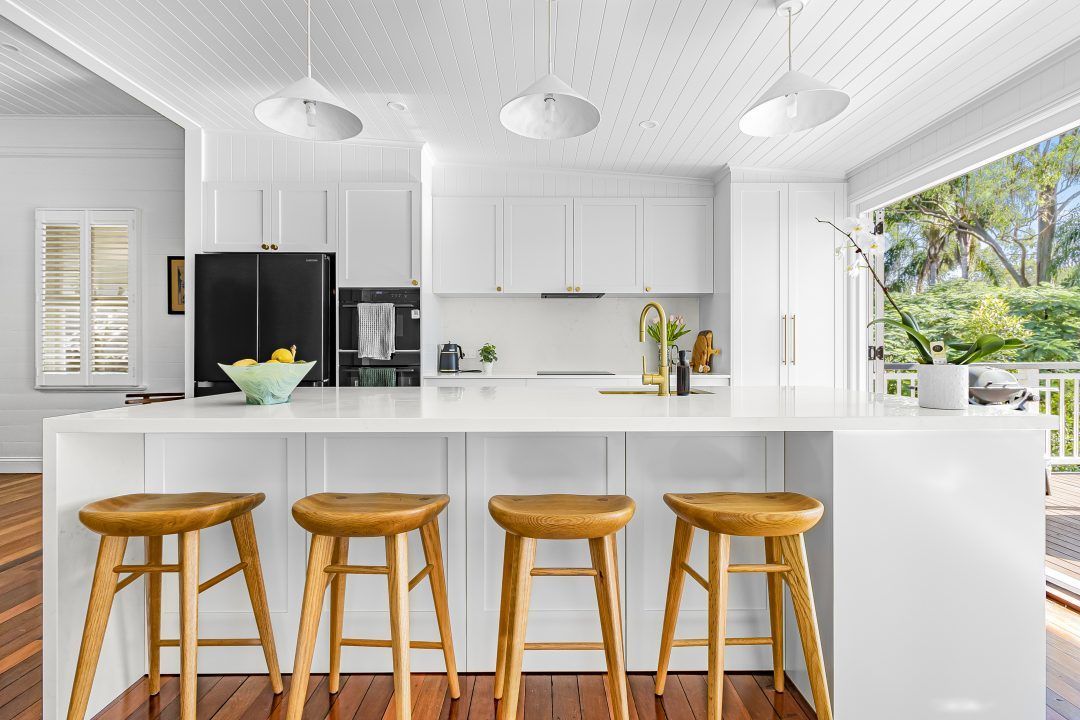 Modern renovated kitchen in a Brisbane home featuring open-plan layout, stone benchtops, and natural