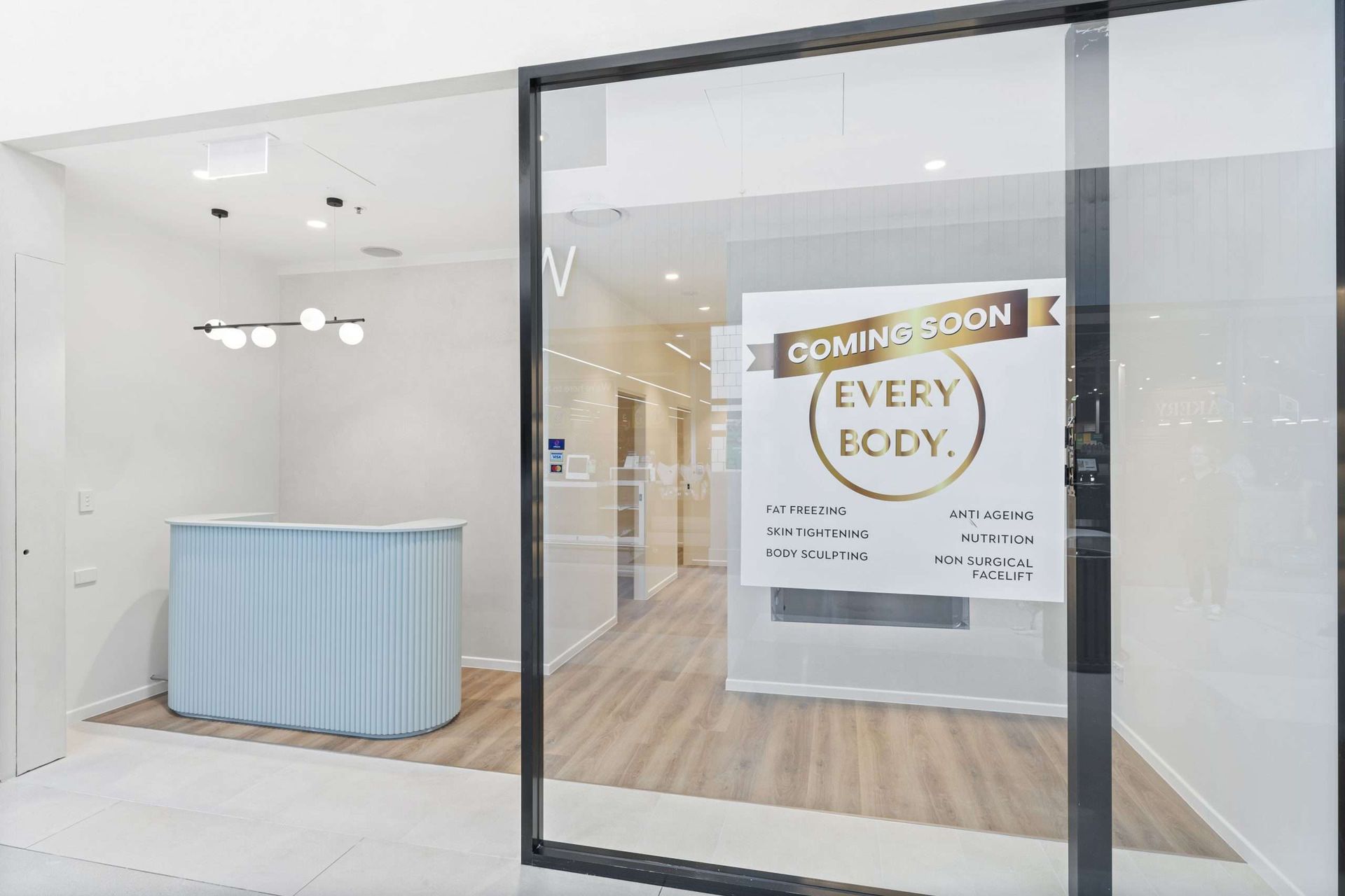 Entrance to a studio with a light blue reception desk and a sign that reads