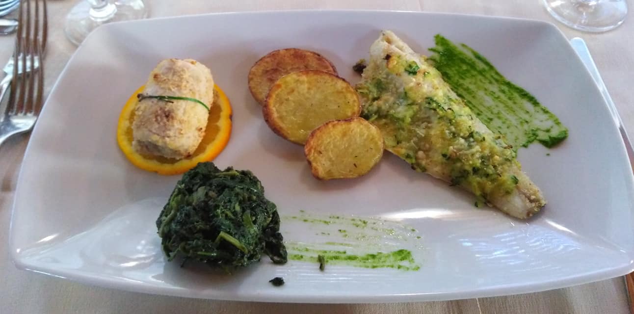 portata di pesce con patate al forno e verdure