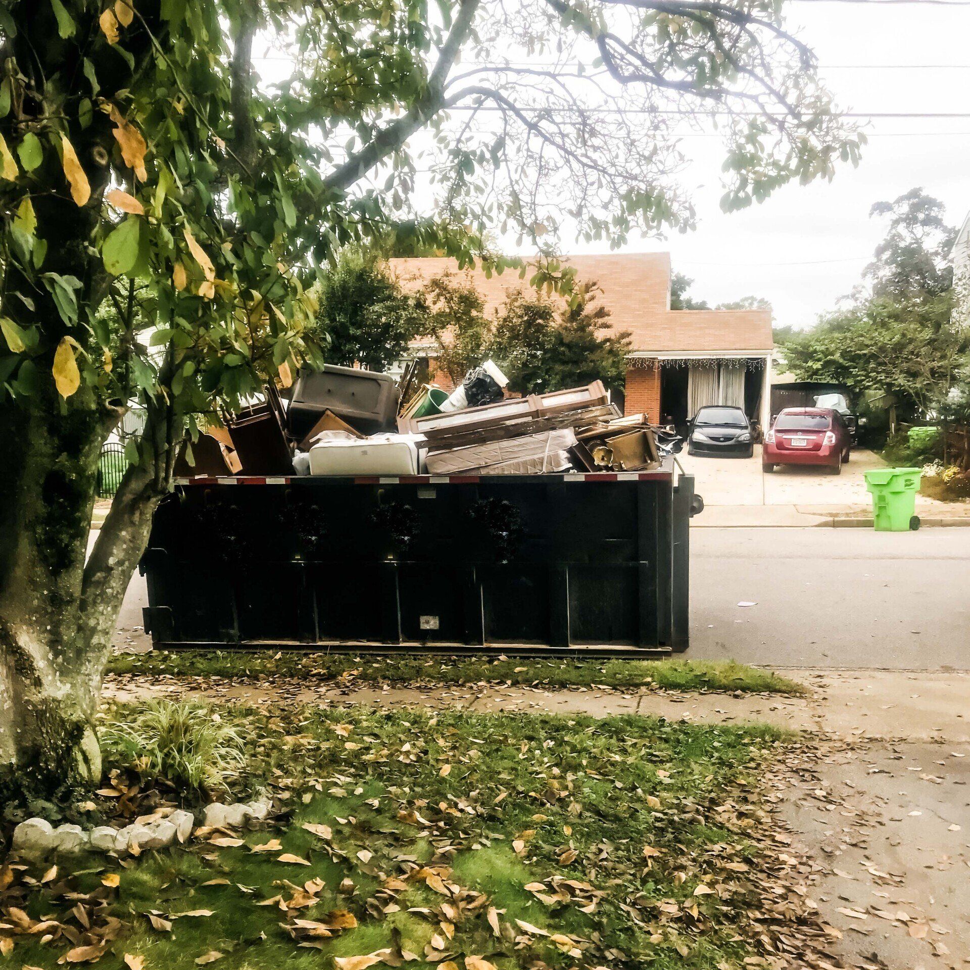 a dumpster is full of junk in front of a house