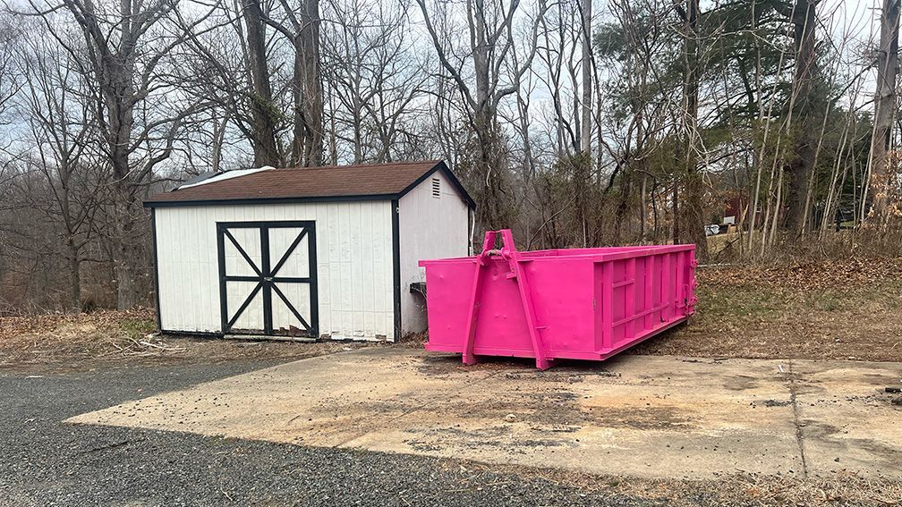 Xpress Dumpster Rentals delivering a pink roll-off dumpster in Warrenton, VA 